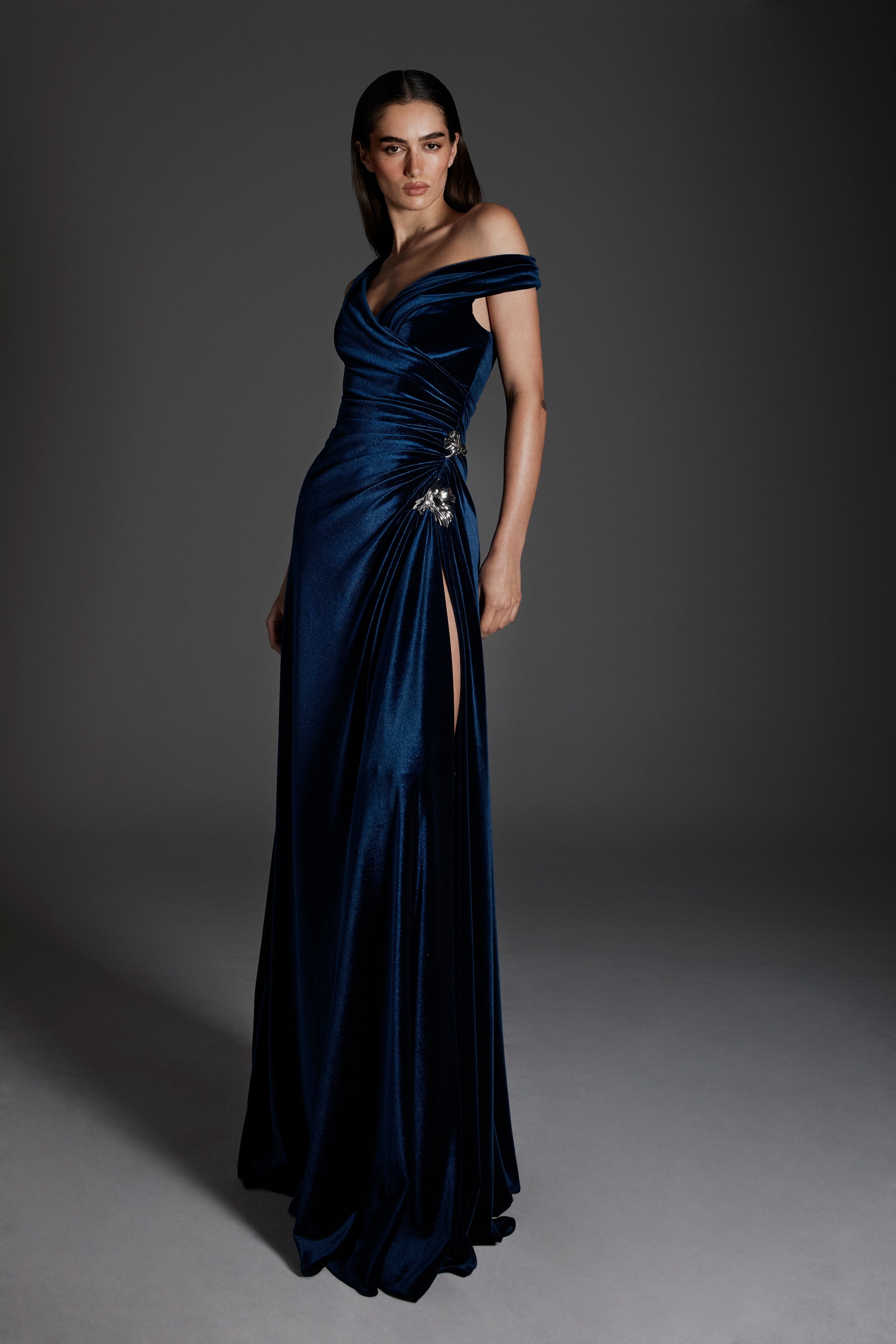 Monique Lhuillier Fall 2026 Navy stretch velour asymmetric off-the-shoulder gown with floral embellishment - lookbook.