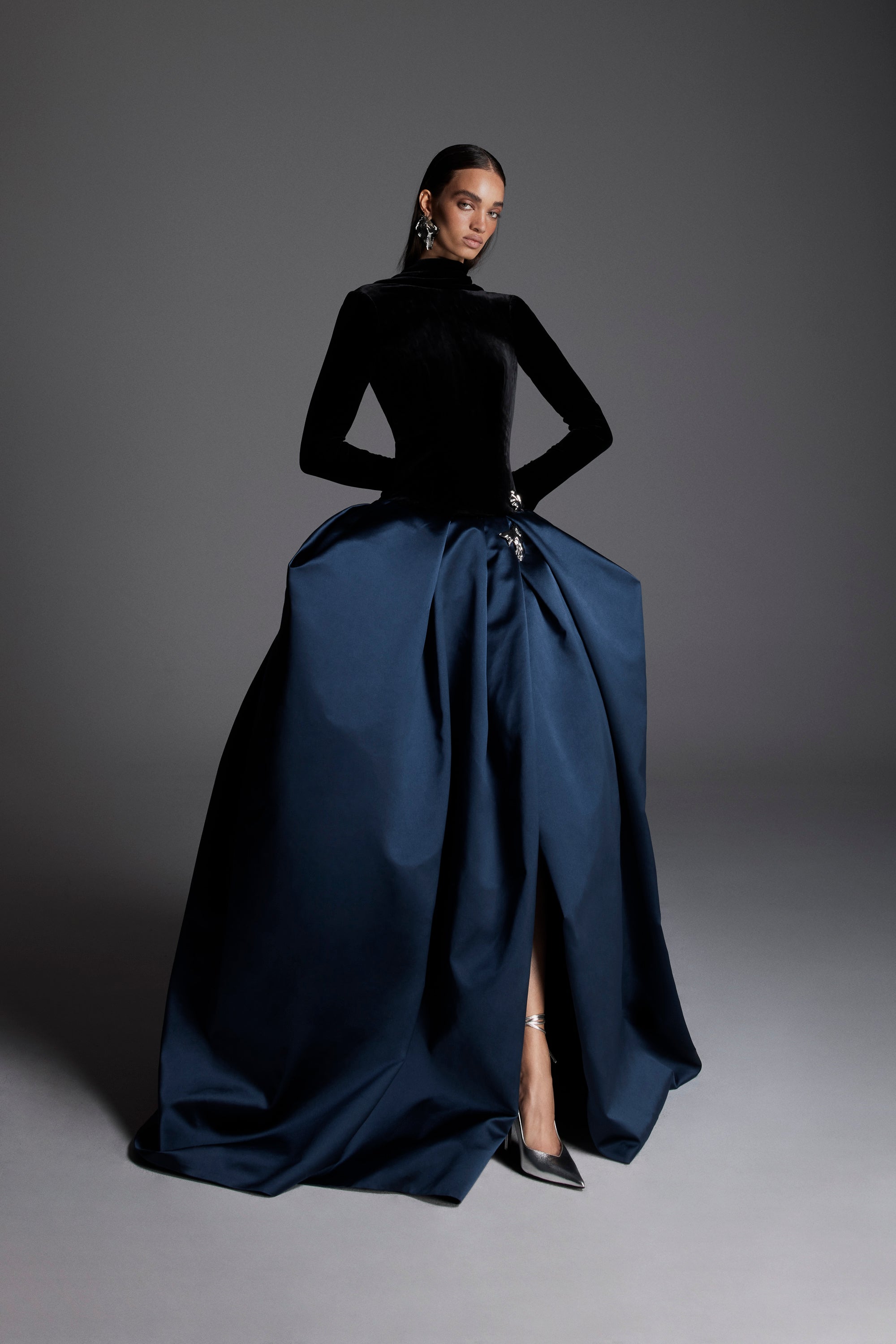 Monique Lhuillier Fall 2026 Noir/Navy velvet and duchesse satin long sleeve dropped waist ballgown with floral  embellishment- lookbook.