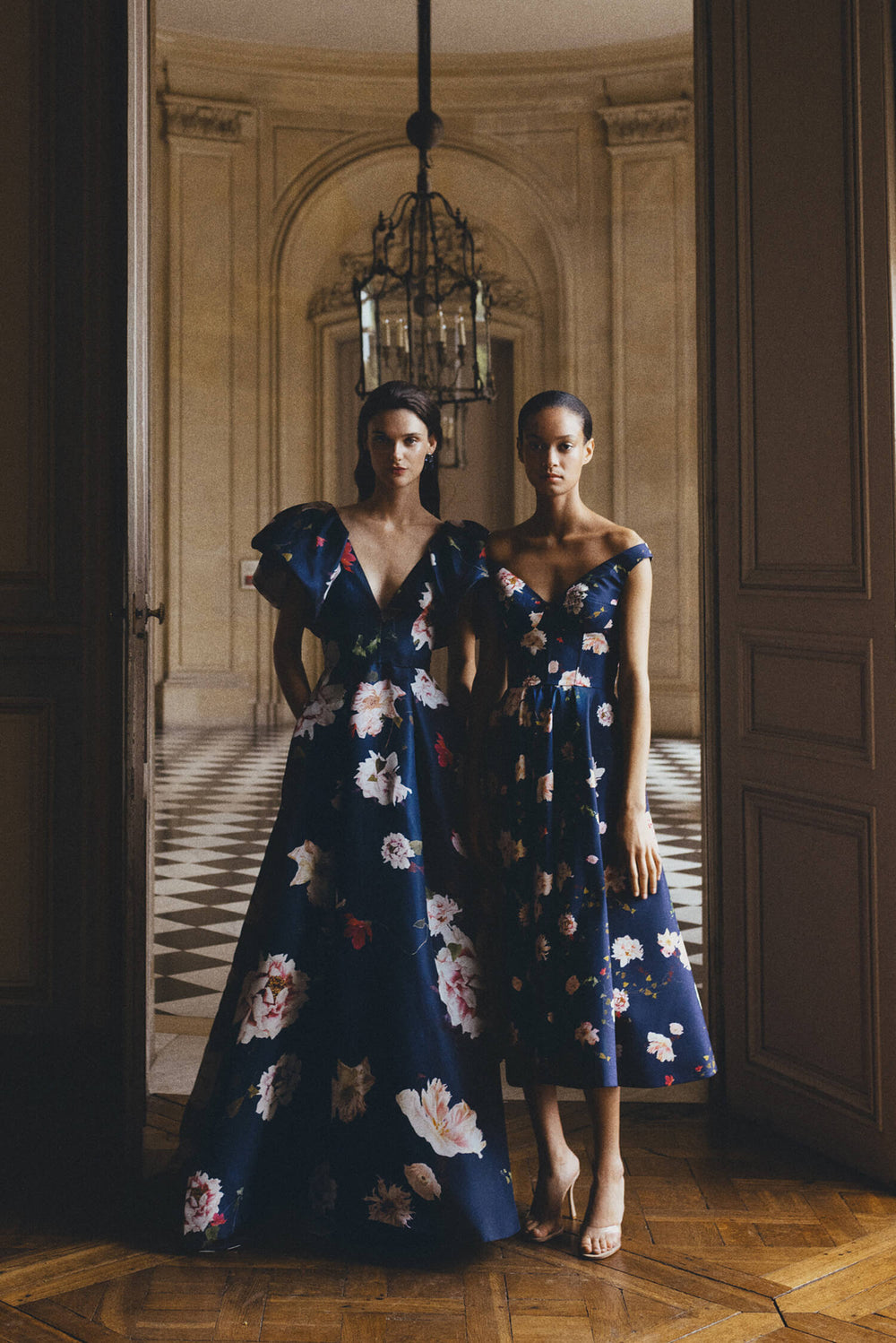 Monique Lhuillier Spring 2024 navy floral gazar gown with deep v neckline, ruffle flutter sleeves and pockets.