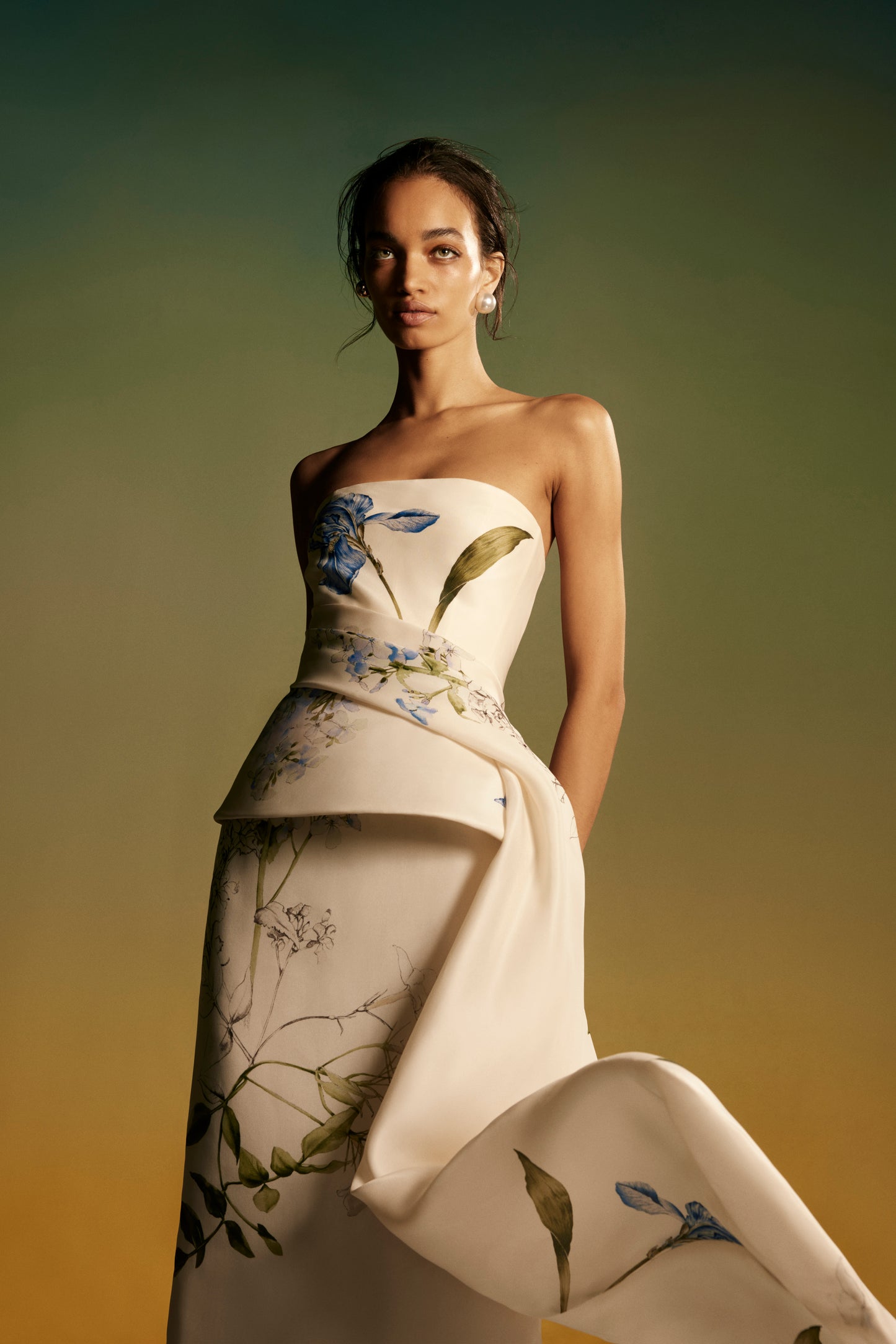 Monique Lhuillier Spring 2026 lookbook image - model wearing Ivory/Multi strapless draped peplum gown in Iris printed gazar