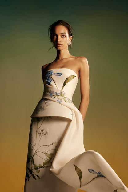 Monique Lhuillier Spring 2026 lookbook image - model wearing Ivory/Multi strapless draped peplum gown in Iris printed gazar
