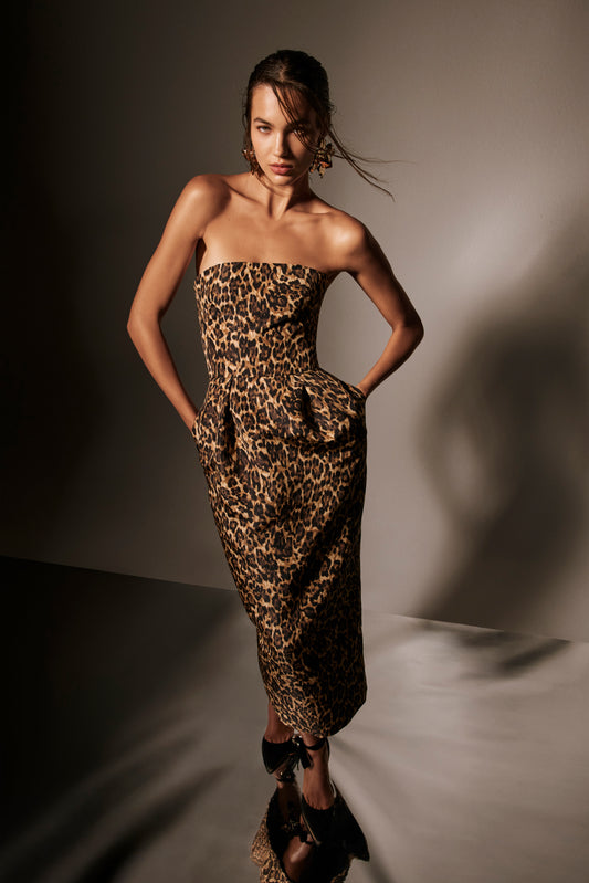 Monique Lhuillier Spring 2026 lookbook image - model wearing leopard faille strapless cocktail dress with pockets 
