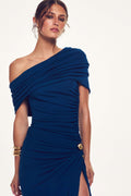 Monique Lhuillier Spring 2027 Sapphire Crepe Jersey asymmetric draped gown with gold metal piercing at hip - lookbook.