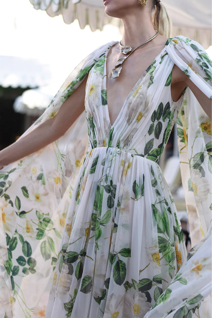 Monique Lhuillier Spring 2025 Draped, v-neck gown in Rose Printed Chiffon with low back and flowing, integral cape - neckline - lookbook.