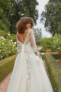 Model in strapless embroidered a-line gown with tulle shawl