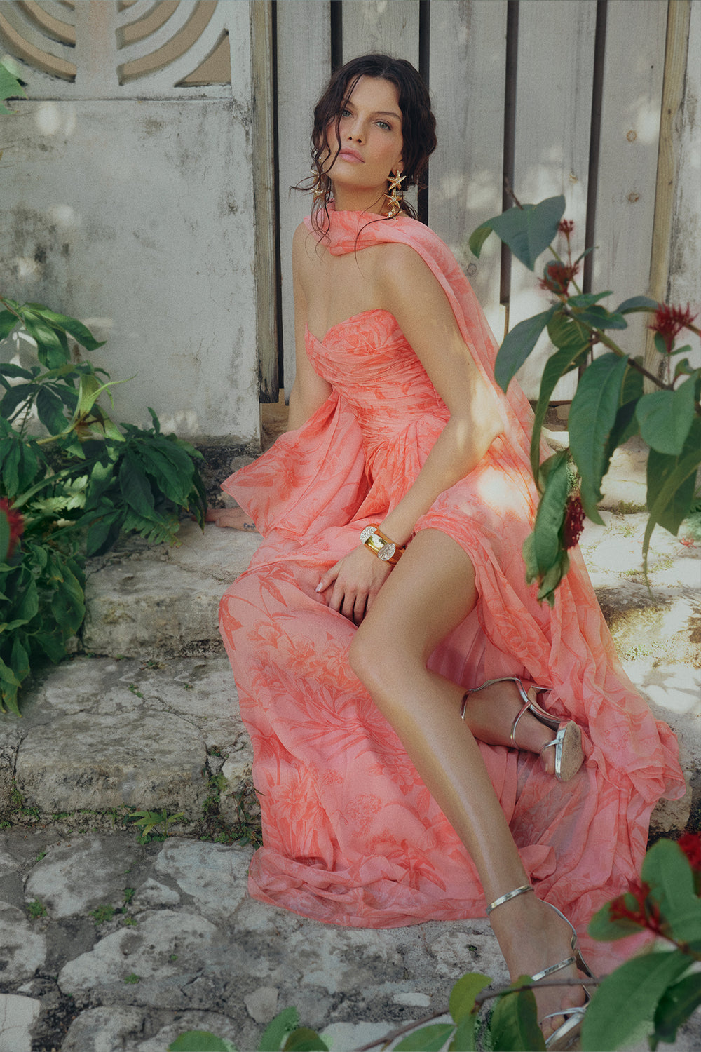 Monique Lhuillier Spring 2025 strapless rosette coral chiffon gown with detached neck scarf and front leg slit.