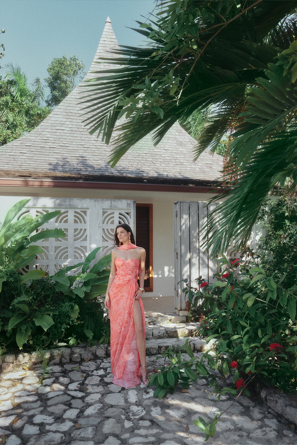 Monique Lhuillier Spring 2025 strapless rosette coral chiffon gown with detached neck scarf and front leg slit.