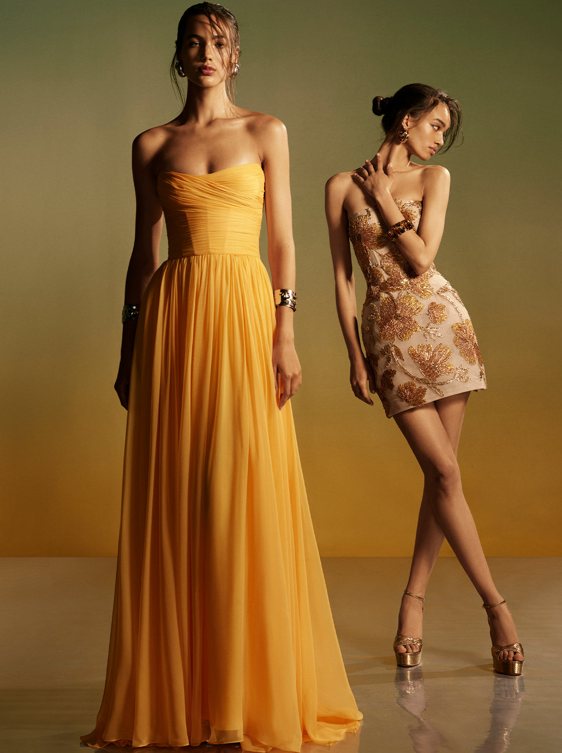 Monique Lhuillier Spring 2026 - model on left wearing Mango chiffon strapless gown, model on right wearing gold embroidered mini dress -lookbook