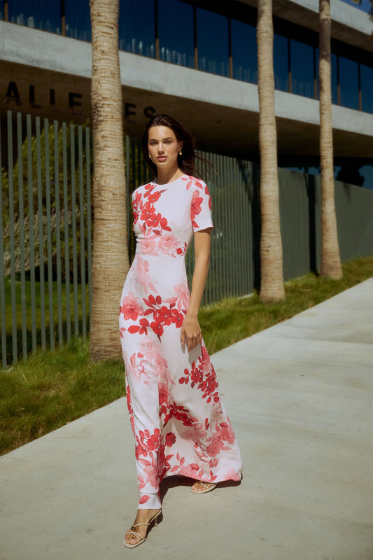 Monique Lhuillier Spring 2026 Powder Pink Multi Rose Ombre Printed Crepe Bracelet sleeve sheath dress - model walkig on sidewalk outside.