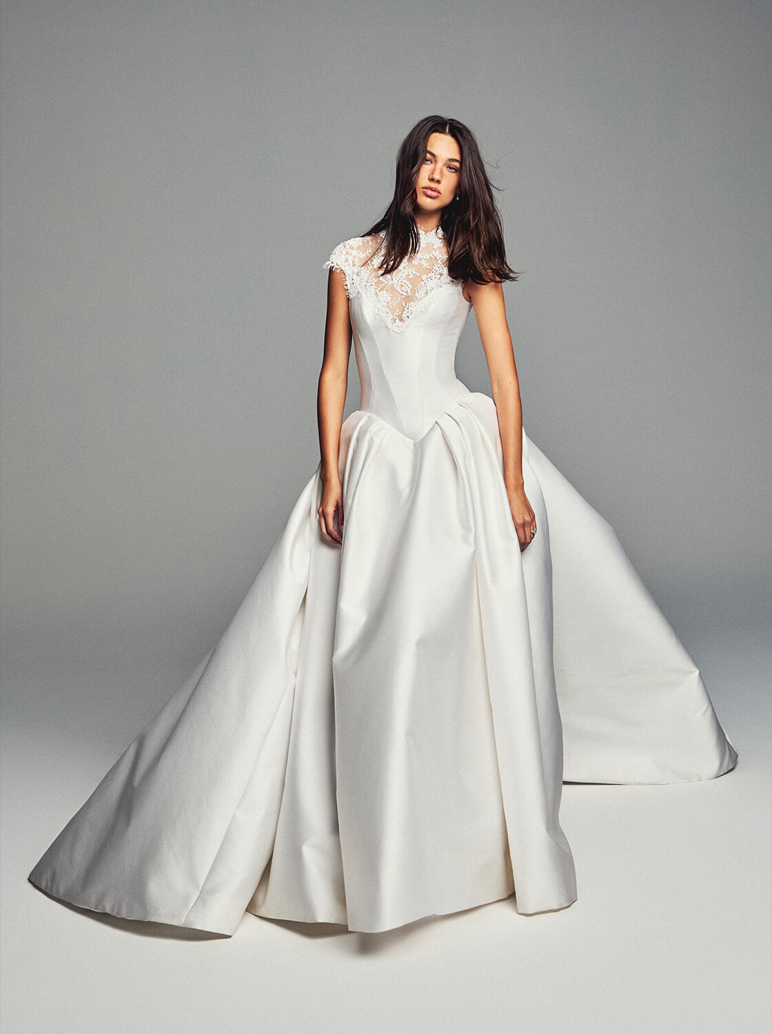Monique Lhuillier Spring 2027 Bridal Corseted basque waist Spencer ball gown with high neck cap sleeve neckline in silk white Mikado and re-embroidered lace.