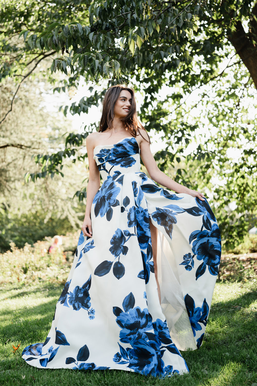 Monique Lhuillier Spring 2025 strapless ballgown with pockets, draped bodice and high leg slit in nautical blue & silk white rose printed gazar.