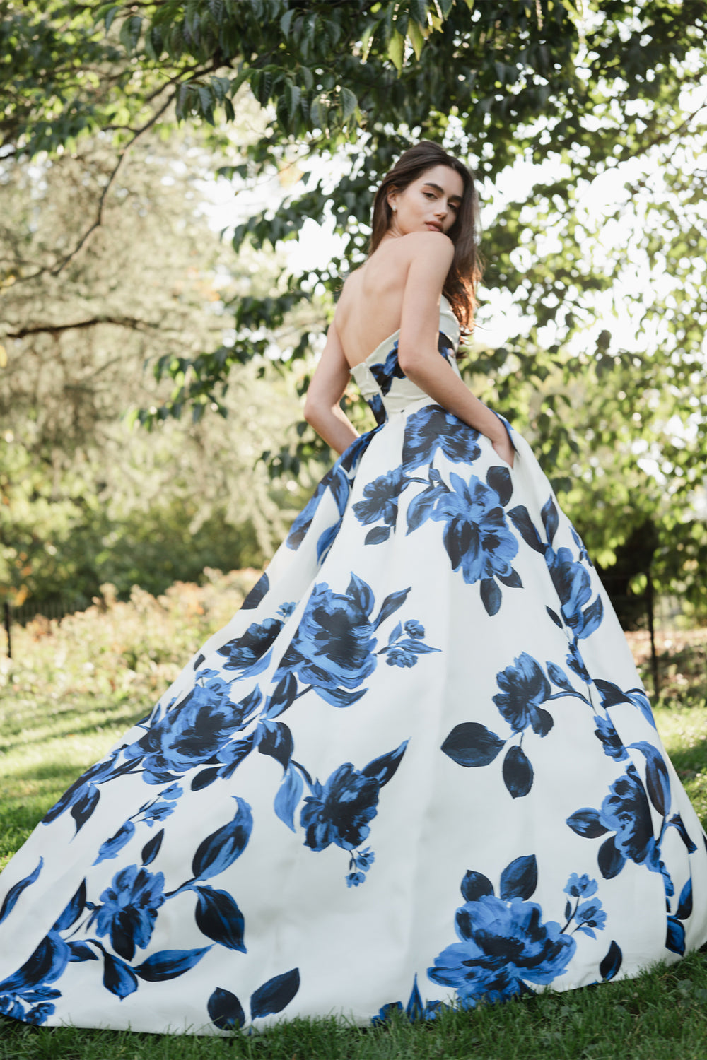 Monique Lhuillier Spring 2025 strapless ballgown with pockets, draped bodice and high leg slit in nautical blue & silk white rose printed gazar.