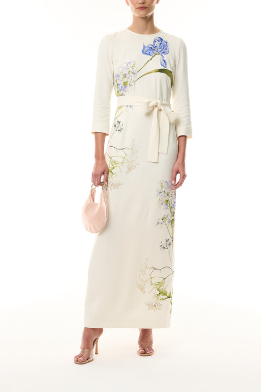 Monique Lhuillier Spring 2026 Ivory/Multi Iris Printed Crepe Bracelet sleeve sheath dress with belt - front with Blush Demi Evening Bag . 