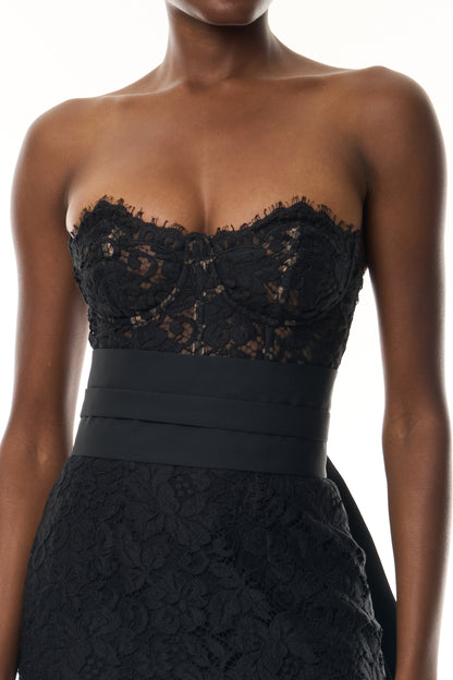Monique Lhuillier Fall 2026 Strapless Midi Cocktail Dress in Noir Peony lace with Noir Silk Faille sash and train - fabric. 