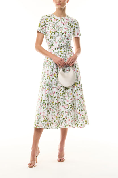 Monique Lhuillier Fall 2026 Short Sleeve Floral Day Dress in Silk White/Multi Ivy Bloom Printed Stretch Cotton Poplin with jewel neckline, belt, pockets and a-line skirt - front with Pearl Demi Evening Bag. 