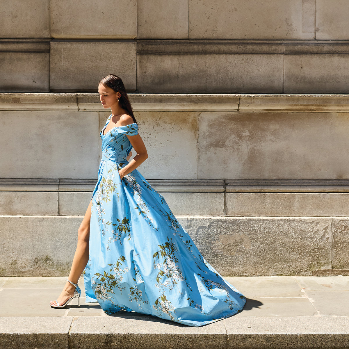 Monique Lhuillier Fall 2026 Blue wisteria printed taffeta asymmetric off-the-shoulder draped ballgown with slit- lookbook. 