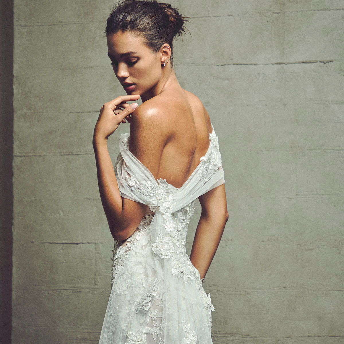 Monique Lhuillier Fall 2027 Bridal Skylark Strapless dropped waist trumpet gown in ivory embroidered appliqué lace with coordinating wrap and train - lookbook.