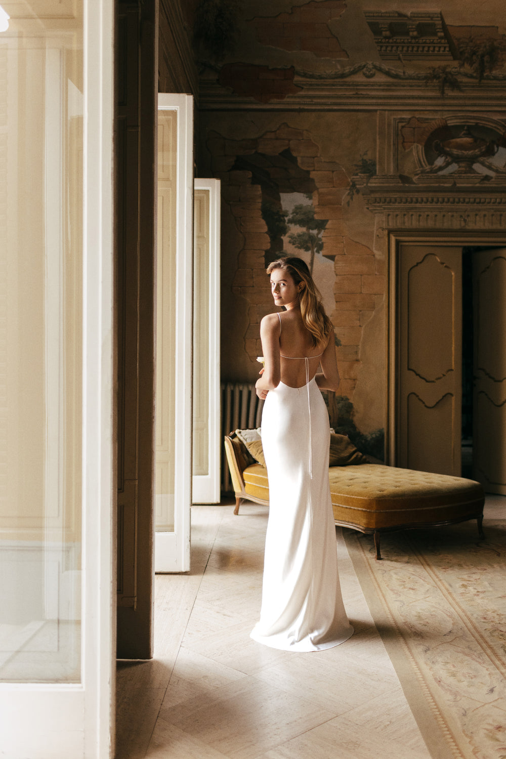 Monique Lhuillier Bridal Spring 2023 draped crepe satin Viola gown with spaghetti straps and low back.