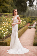 Model in fitted cap sleeve v-neck embroidered gown