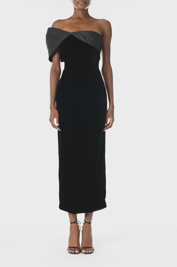 Monique Lhuillier Fall 2024 asymmetric, off the shoulder sheath dress in noir silk faille and velvet with draped twist detail at neckline - video.