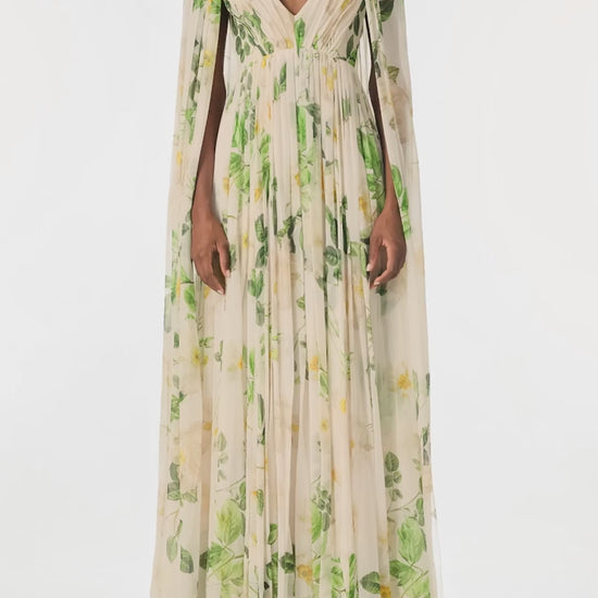 Monique Lhuillier Spring 2025 Draped, v-neck gown in Rose Printed Chiffon with low back and flowing, integral cape - video.