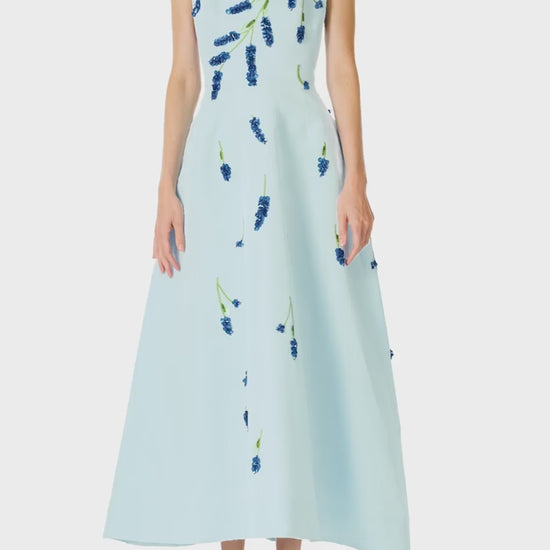 Monique Lhuillier Spring 2025 Sleeveless, tea-length dress with pockets in Powder Blue faille with Lavender-patterned embroidery - video.