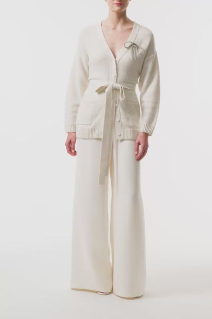 Monique Lhuillier Fall 2025 long sleeve cardigan in ivory sequin cashmere with bow brooch and self-tie belt - video.
