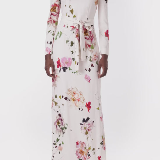 Monique Lhuillier jewel neck, tea-length gown with long sleeves and self-tie sash in silk white floral fabric.