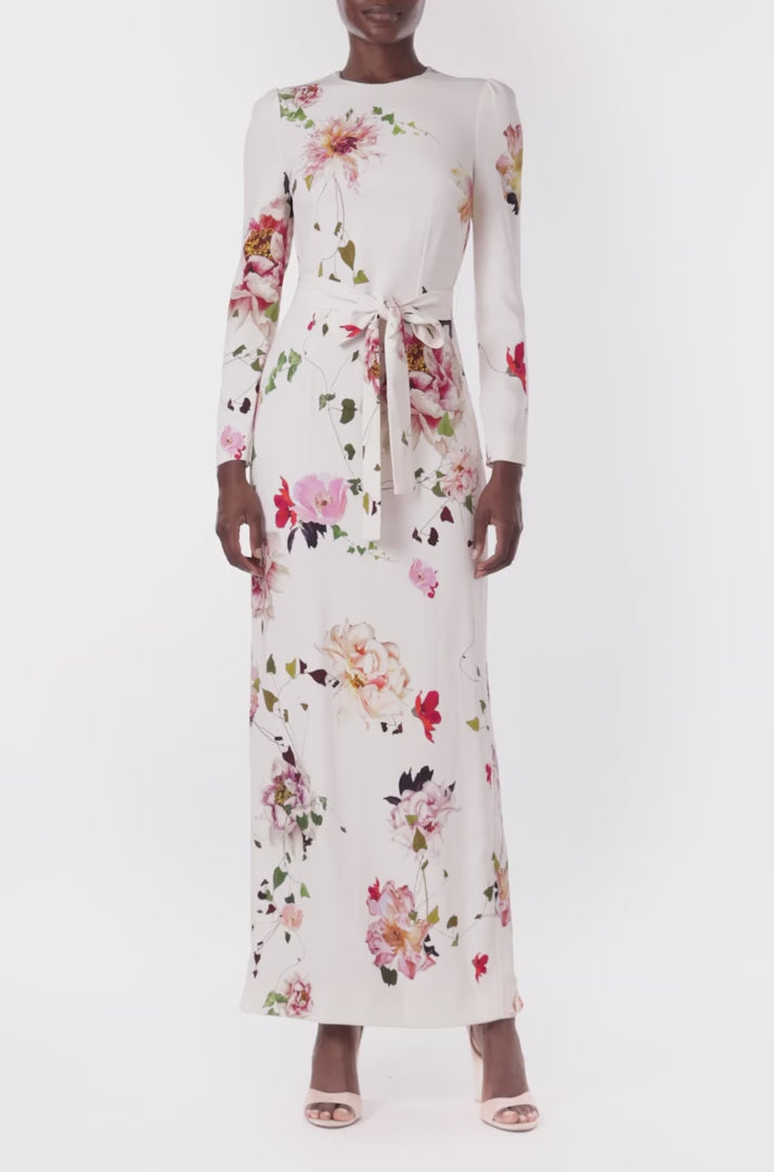 Monique Lhuillier jewel neck, tea-length gown with long sleeves and self-tie sash in silk white floral fabric.