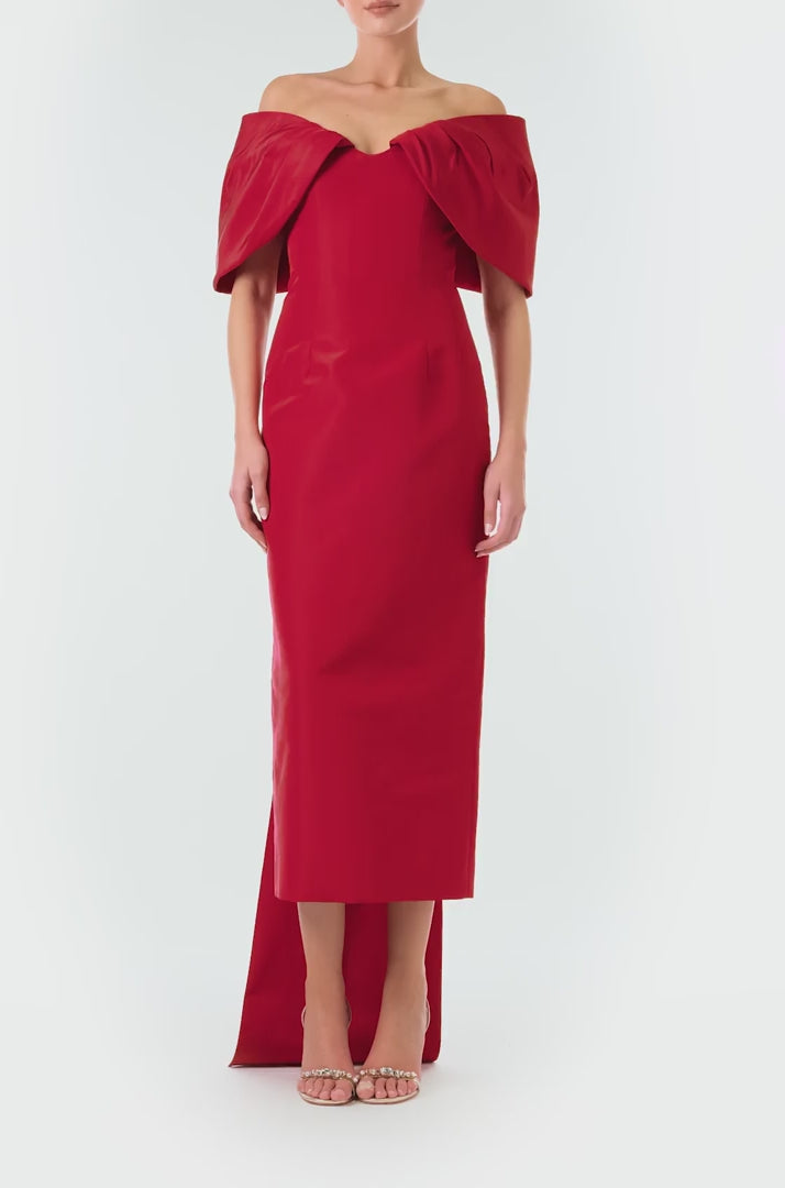 Monique Lhuillier Fall 2024 off-the-shoulder tea length column dress with draped neckline and bow-train in pomegranate silk faille - video.