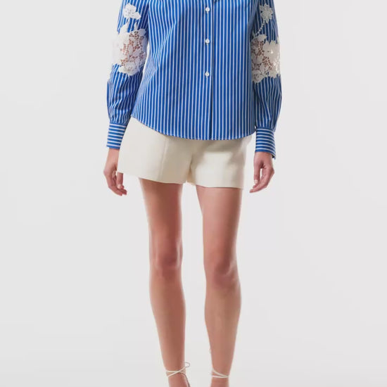 Monique Lhuillier Spring 2025 Long sleeve, button front collared striped shirt with lace detailing in Nautical Blue poplin with White lace details  - video.