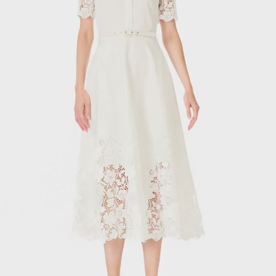 Monique Lhuillier Spring 2025 white cotton poplin dress with lace applique inserts, short sleeves, button down front bodice and belted waist - video.