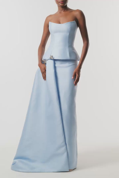 Monique Lhuillier Fall 2026 Pale Blue Mikado Piqué strapless dropped waist peplum gown with column skirt, side train and silver floral embellishment - video.
