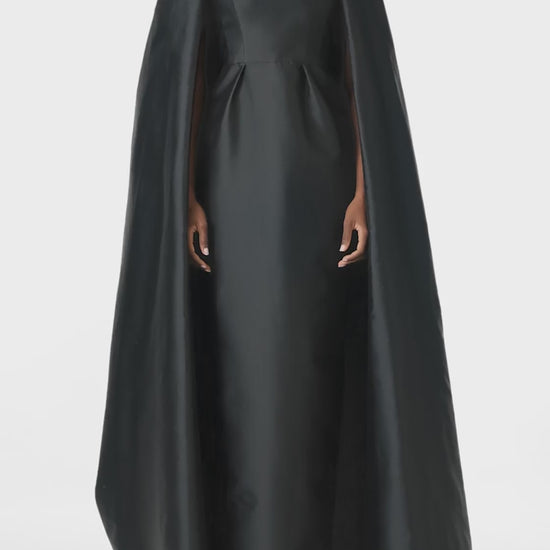 Monique Lhuillier Fall 2024 sleeveless, scoop neck column gown with integral cape in noir mikado fabric - video.