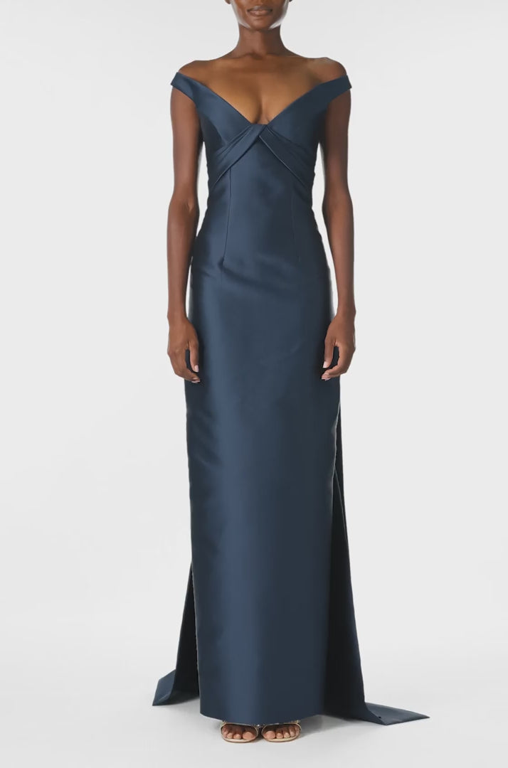 Monique Lhuillier Spring 2025 Off the shoulder gown with draped, low cut V-neckline and with integral draped ties down the back in Lapis Mikado - video.