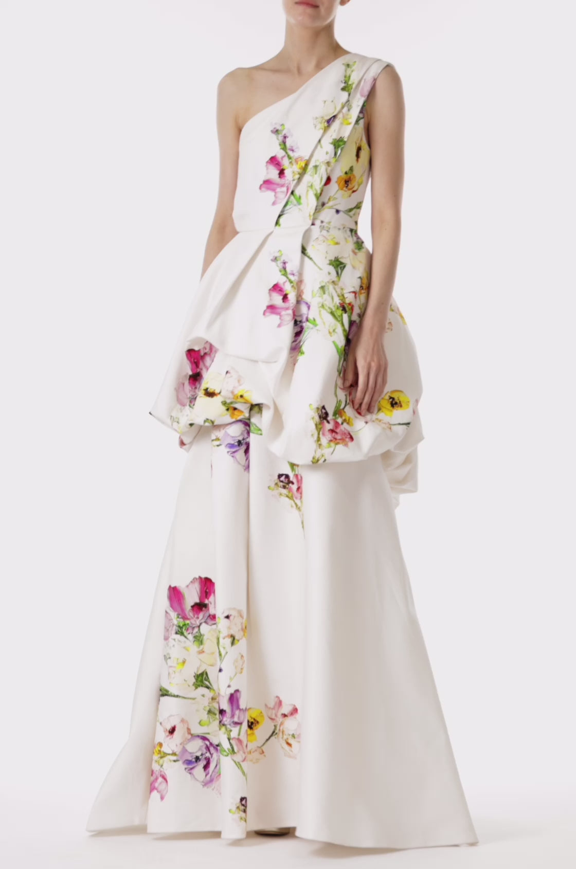 Monique Lhuillier silk white botanical printed mikado gown with one shoulder neckline and tufted skirt.