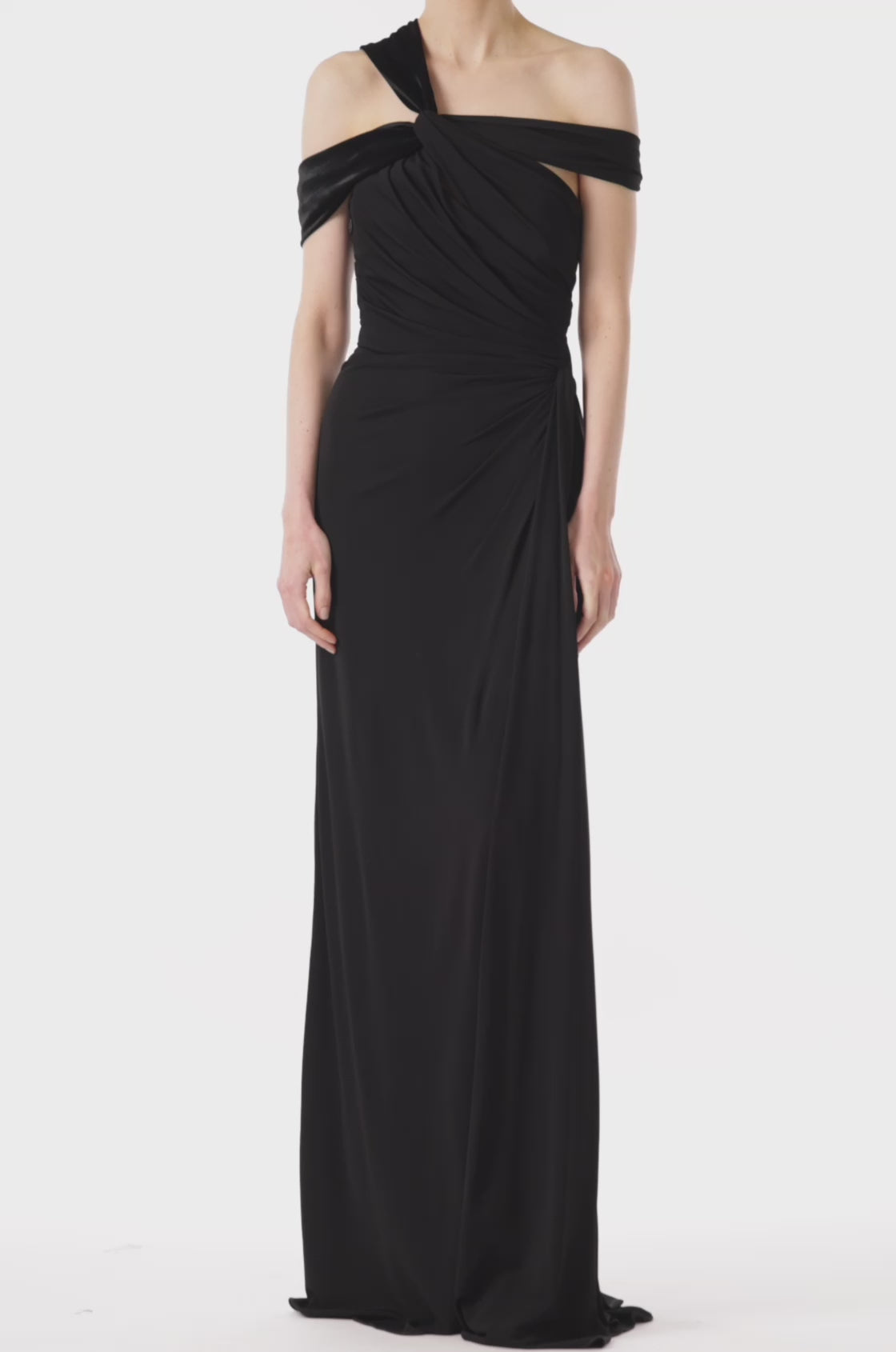 Monique Lhuillier asymmetric neckline gown in black jersey and velvet with draped bodice and front slit.