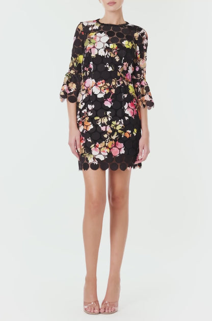 Monique Lhuillier Spring 2024 jewel neck mini dress in black/floral printed circle lace with bracelet length bell sleeves - video.