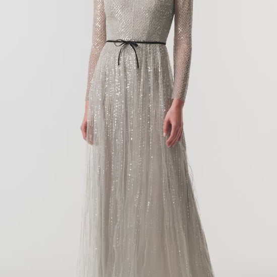 Monique Lhuillier Fall 2026 silver, long sleeve embroidered tulle gown with black velvet belt at waist - video.