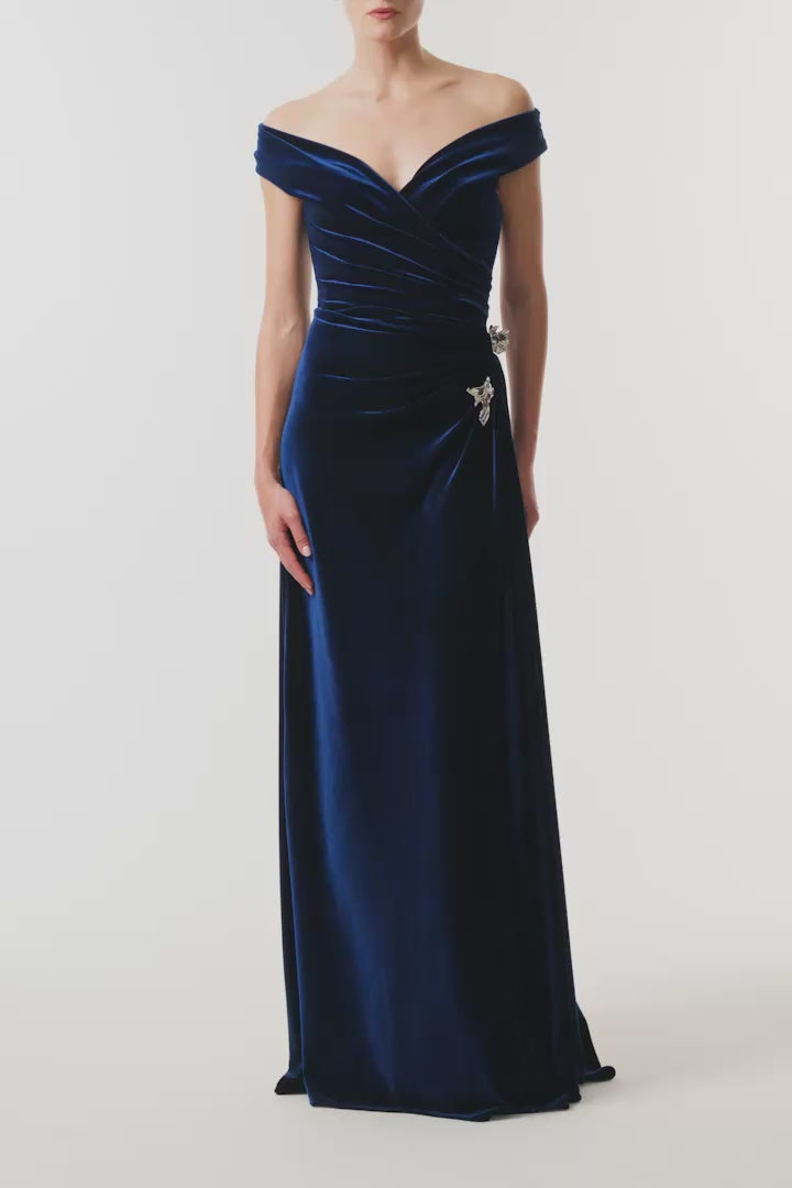 Monique Lhuillier Fall 2026 Navy off-the-shoulder stretch velour draped floor length gown with slit and silver floral embellishment - video.