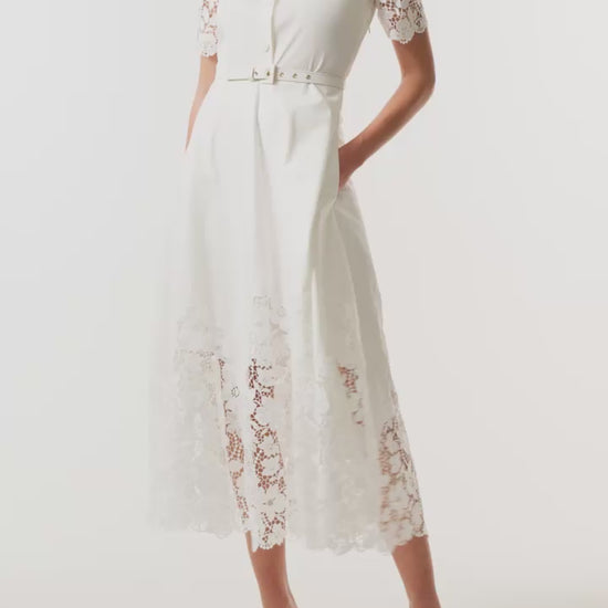 Monique Lhuillier Spring 2025 white cotton poplin dress with lace applique inserts, short sleeves, button down front bodice and belted waist - video.