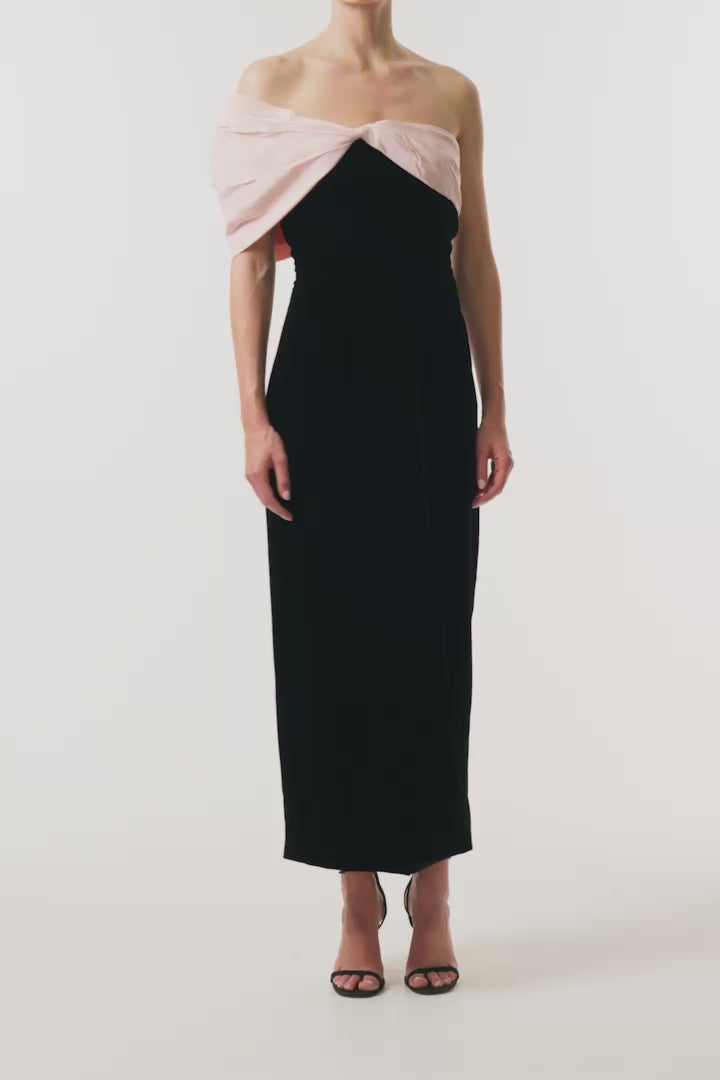 Monique Lhuillier Fall 2024 black velvet sheath dress with pale blush off the shoulder drapeda symmetric twist detail at neckline - video.