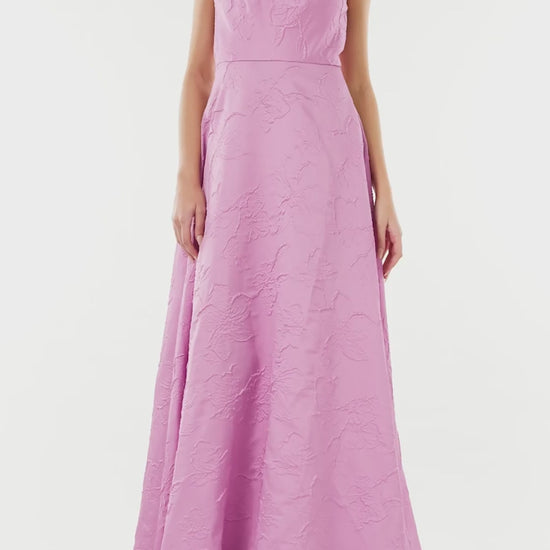 ML Monique Lhuillier floor length dress in orchid jacquard fabric with one shoulder and bow neckline.