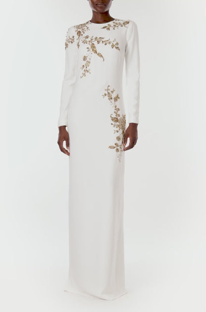 Monique Lhuillier silk white jewel neck, long sleeve column gown with gold embroidery.