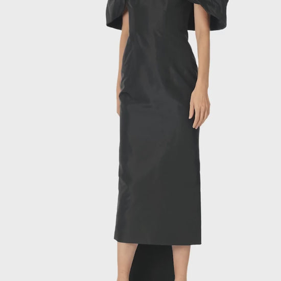 Monique Lhuillier Fall 2024 Off-the-shoulder tea length column dress with draped neckline and train in noir silk faille - video.