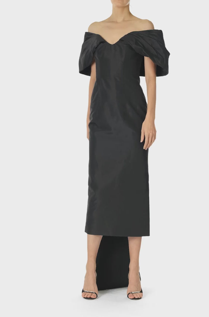 Monique Lhuillier Fall 2024 Off-the-shoulder tea length column dress with draped neckline and train in noir silk faille - video.