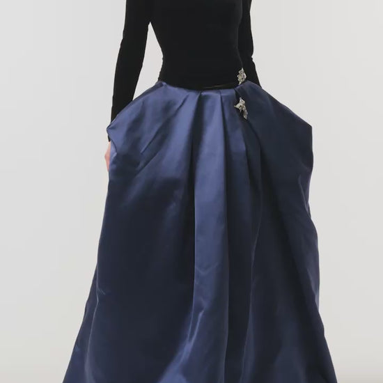 Monique Lhuillier Fall 2026 Noir and Navy Velvet and Duchess Satin long sleeve high neck pleated ballgown with silver floral embellishment - video. 
