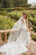 Model sitting in fitted lace strapless gown and veil with lace trim