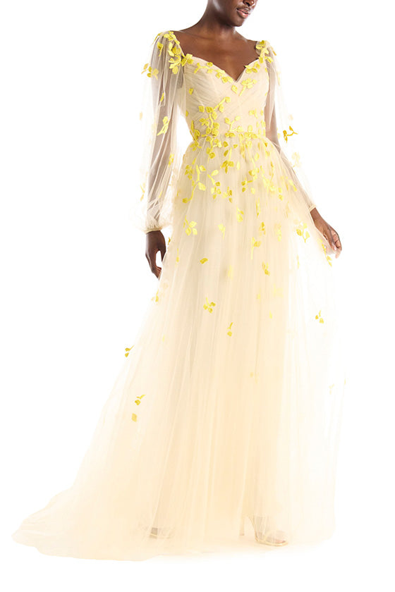 Cameo colored tulle gown with yellow embroidery over illusion long sleeves and sweetheart neckline.